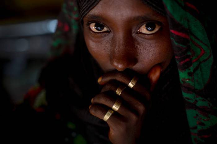 An Afar woman poses for a photograph in her hut in woreda of Geega near Logya. Kate Holt.