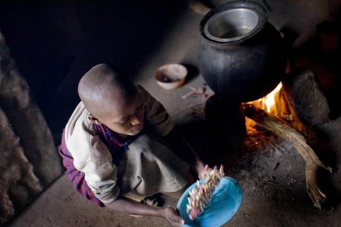 Baby Larumbe sifts through beans before cooking them on her family's homestead. Kate Holt.