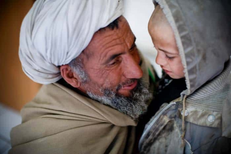 A grandfather comforts his grandson who is waiting to see a doctor in the OPD unit of Bost Hospital. Kate Holt.