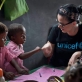 Katy Perry fist-bumps a young boy at Sahavola pre school in Analanjirofo. Kate Holt.