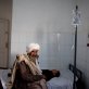 Salim, an eight year old boy, accompanied by his grandmother, Hajji, is treated for an allergy to some medicine. Kate Holt.