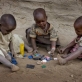 Neema Moshi's little sister Eva and her two little cousins play with old bottle tops. Kate Holt.