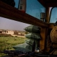 A US Marine smokes a cigarette while looking over a poppy field next to their Combat Outpost in Lakari Bazaar. Kate Holt.