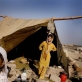 Noorbibi poses for a photograph with one of her daughters outside her shelter. Kate Holt.