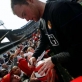 Wayne Rooney, from Manchester United, signs autographs for young fans after a pre match practise. Kate Holt.