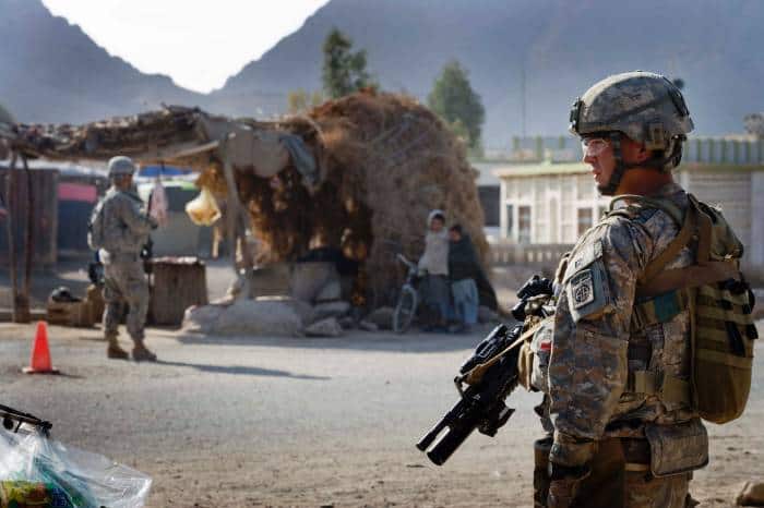 A soldier from the 82nd Airborne Division of the US army pass by the passes by a market stall. Kate Holt.