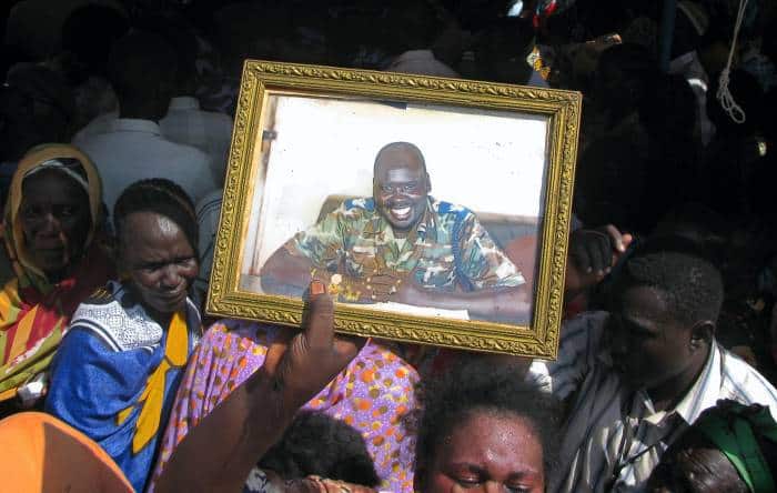 A family member holds up a photograph of Officer Abut who was killed in Yambio while on duty. Kate Holt.