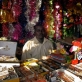 A man sits in his shop that is selling Christmas Decorations in Custom Market. Kate Holt.