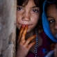 A young girl whose family have been displaced by recent fighting in Helmand poses for a photograph. Kate Holt.