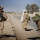 A US Marine walks passed a man with his donkey carrying wheat while out on patrol in Garmsir Helmand Province. Kate Holt.