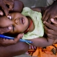 Trachoma monitor, Jeremiah Ntors Sankaire examines the eyes of one year old Ezekhiel Lemayian. Kate Holt.
