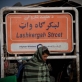 A man walks passed a street sign of Lashkar Gah, in Lashkar Gah, Helmand, Afghanistan. Kate Holt.
