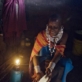 Namayani Ngoliyo stands behind her stepmother Ngaisi who is cooking at her father's house. Kate Holt.