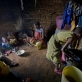 Maua Juma washes the dishes while her mother, Chiku, cooks for the family. Kate Holt.