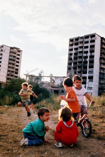 Children play outside of a bombed apartment block in Sarajevo. Kate Holt.
