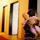 A young girl hides behind her doll at an orphanage in Tuzla for abandoned children. Kate Holt.
