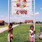 Children stand by the sign for the Village of Dobraje, where Care completed a drinking water project. Kate Holt.