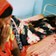 A woman watches over a female relative who is suffering from acute dehydration. Kate Holt.