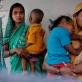 Women poses for photographs with their baby at a community centre, while waiting for their babies to be weighed. Kate Holt.