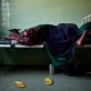 A woman sleeps in a female ward in Benadir Hospital. Many women undergo severe problems in child birth. Kate Holt.